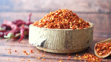 red pepper flakes in wooden bowl