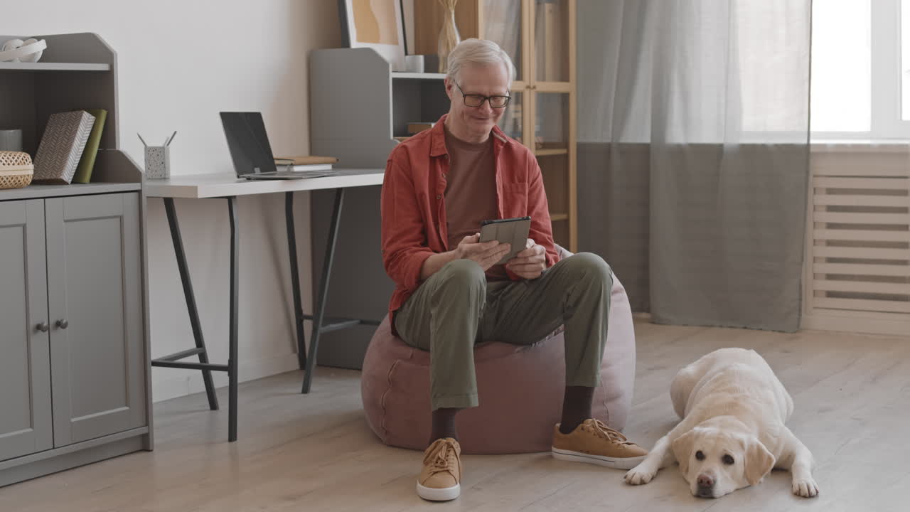 Contemporary Senior Man Using Digital Tablet Indoors