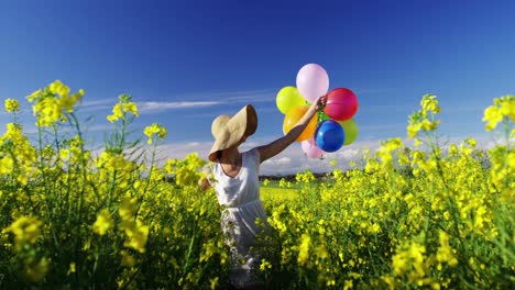 woman walking with colorful balloons in mustard field