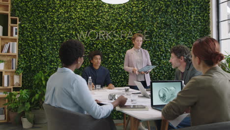 business people meeting caucasian project manager woman showing prototype engine turbine on tablet computer screen presenting design innovation to diverse management group in office boardroom