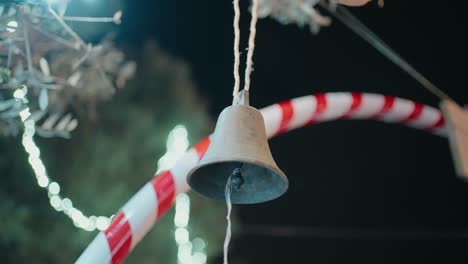 cerca de una campana colgante por la noche rodeada de decoraciones festivas de caña de caramelo