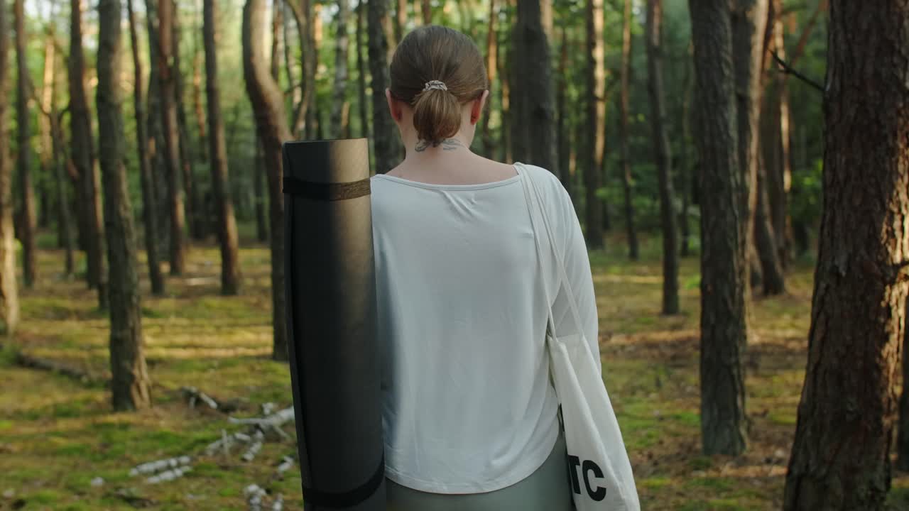 숲 속 의 요가 매트 를 가진 여자