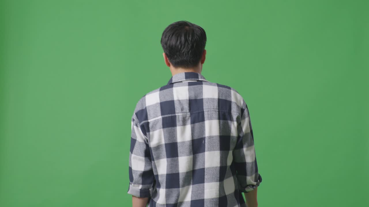 녹색 스크린 배경에서 고 있는 아시아 남자의 뒷면