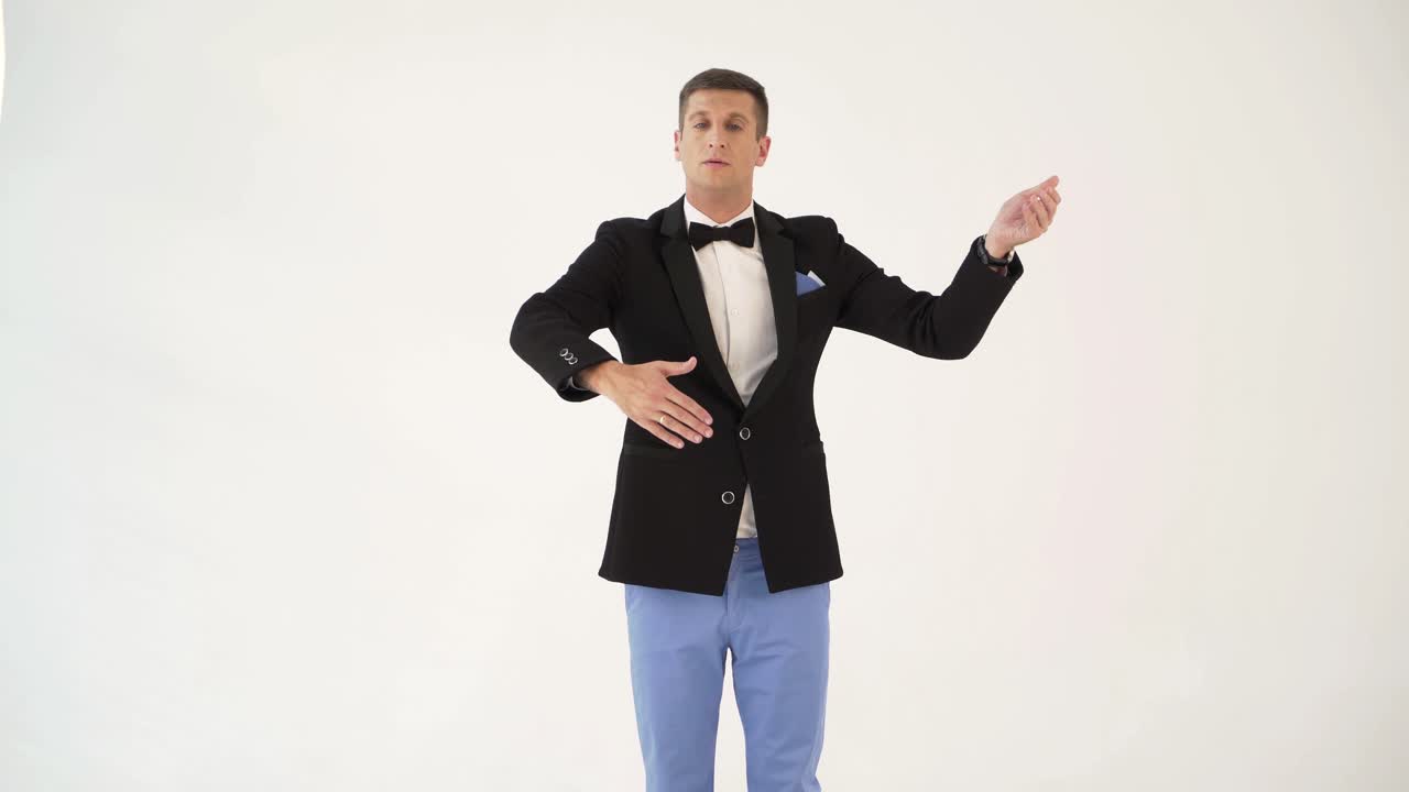 fun man is dancing a waltz on a white background in the studio. Parody of professional dancing with the partner