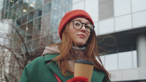 mujer con café caminando por la ciudad