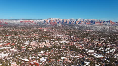 Vista-Aérea-Invernal-De-La-Ciudad-De-Sedona-Con-Rocas-Rojas-Cubiertas-De-Nieve.