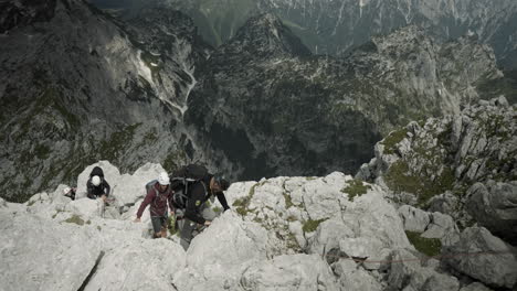 a group of hikers climbing up a moutain in clinbing gear, birdseye perspective, valley visible in background