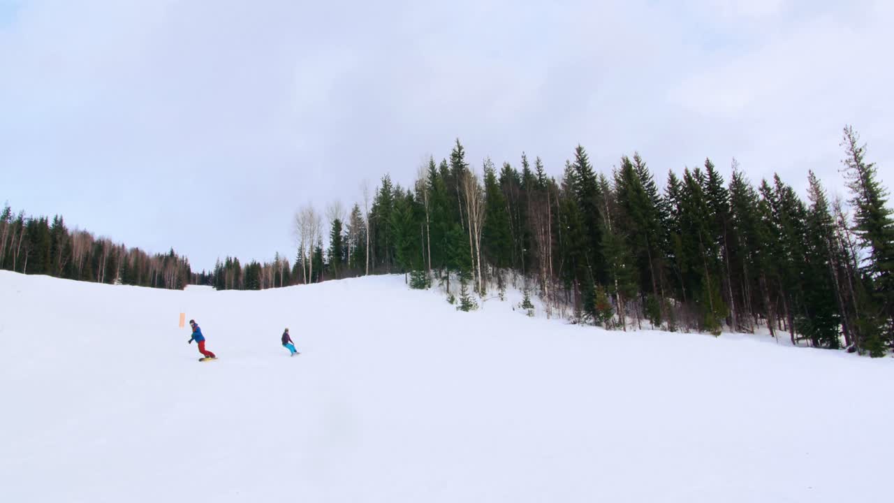 personas haciendo snowboard en una montaña nevada