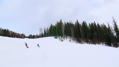 People-snowboarding-on-snowy-mountain