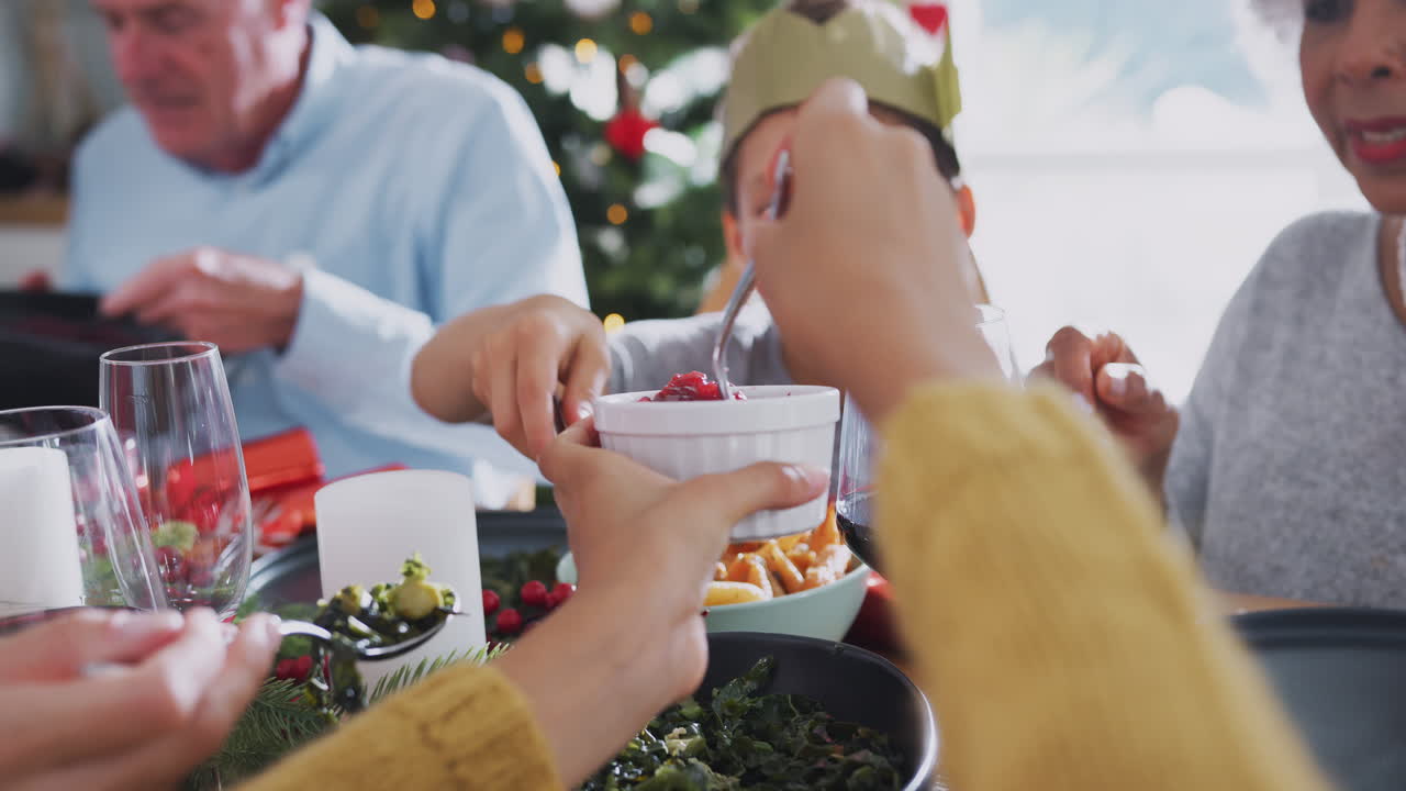 familia de varias generaciones sentada alrededor de la mesa comiendo la comida de navidad en casa