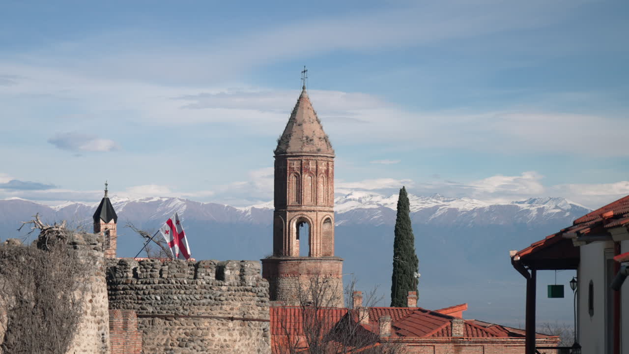 torre de la iglesia de la aldea georgiana con montañas en el fondo