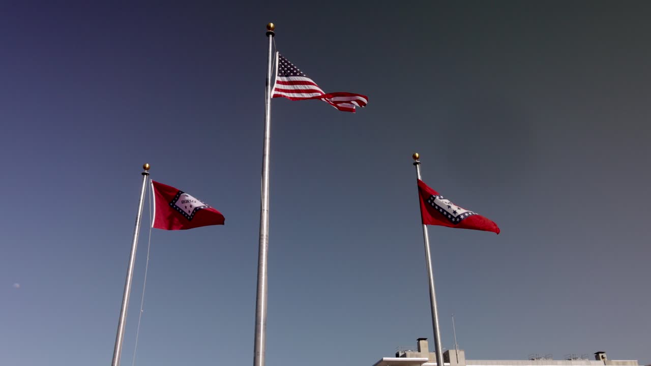 bandera estadounidense y dos banderas del estado de arkansas volando fuera del edificio del capitolio del estado de arkansas en little rock, arkansas con video estable