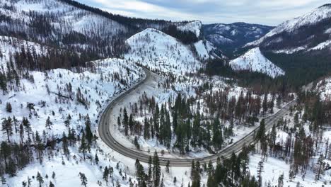 Aerial-view-of-cars-traveling-to-Tahoe-through-snowy-mountains,-Highway-I-50,-El-Dorado-Forrest,-California