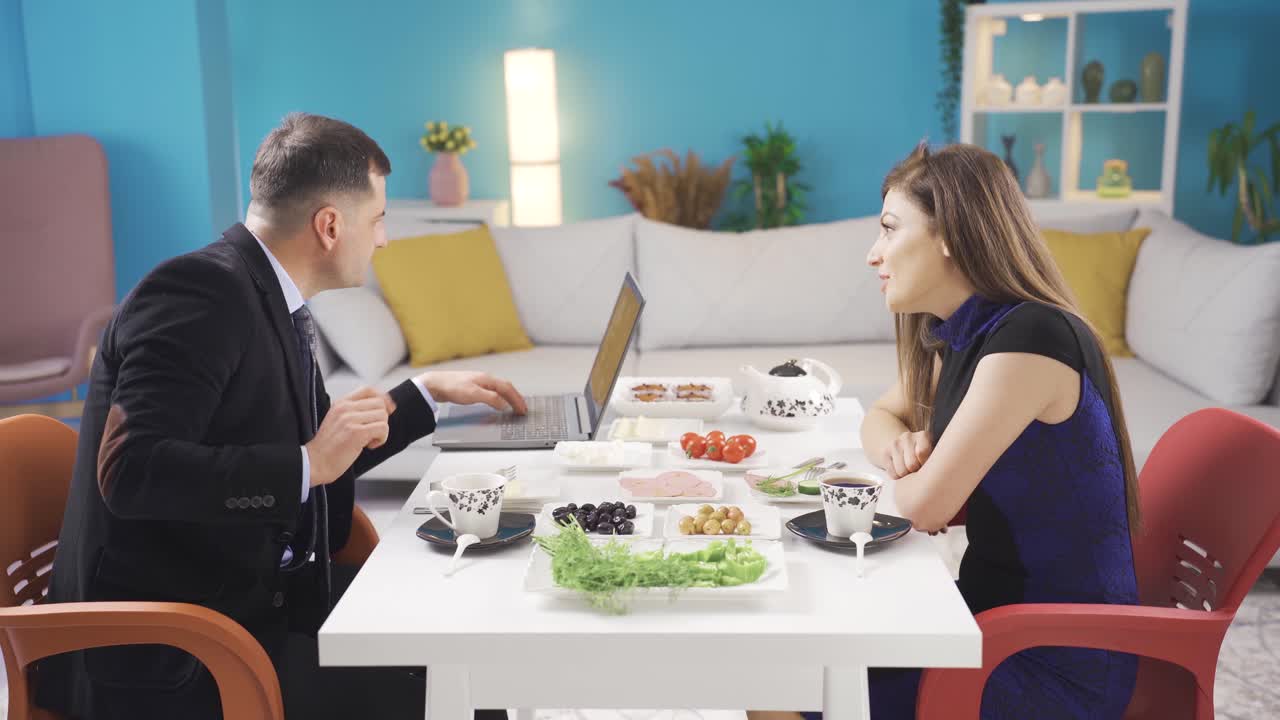 바 ⁇ 고 서두르는 사업가는 집에서 아침 식사를 하는 동안 아내와 대화할 수 없고 아내에게 시간을 할애할 수 없습니다.