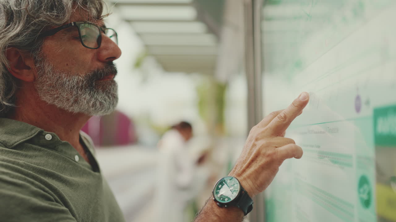 Man reading a bus schedule at a bus stop