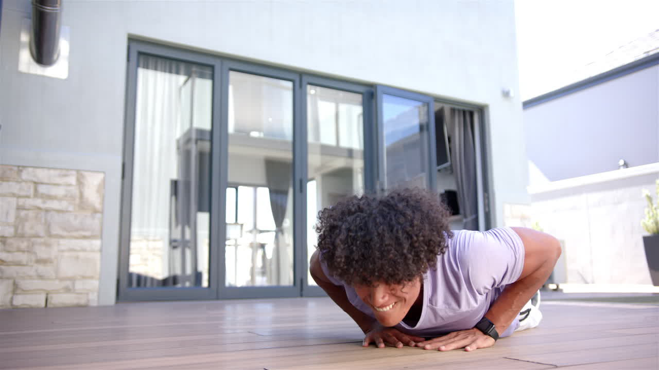 Doing push-ups, man exercising on wooden floor at home, wearing smartwatch, copy space
