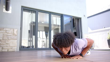 doing push-ups, man exercising on wooden floor at home, wearing smartwatch, copy space