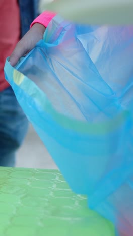 people interacting with a blue plastic bag at an outdoor gathering