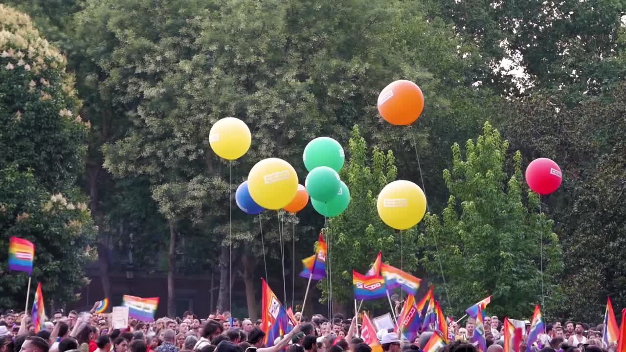 A lively pride march featuring vibrant balloons, celebrating LGBTQ+ pride with enthusiastic participants and festive decorations.