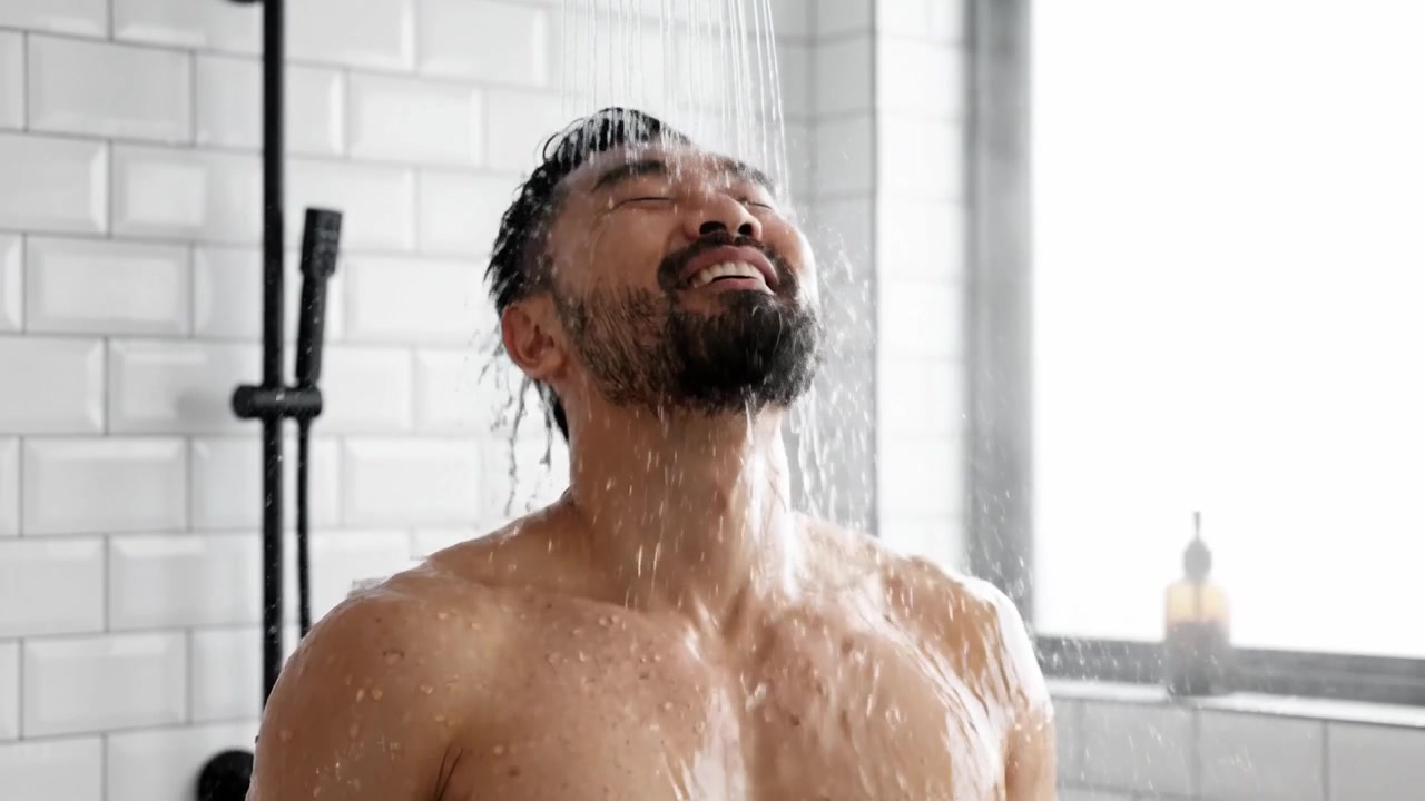 A Man Enjoying a Refreshing Shower Experience, Feeling the Warm Water Flow and Embracing a Moment of Relaxation and Joy in a Bright, Modern Bathroom