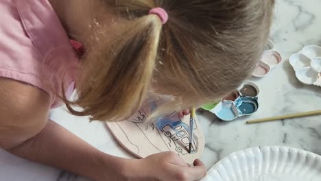 niño pintando una placa de cerámica