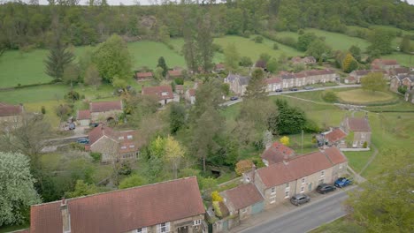hutton-le-hole is a pretty village in north yorkshire. cottages and a few shops around a large green with small beck running through it. low level aerial very early in the morning with nobody about.