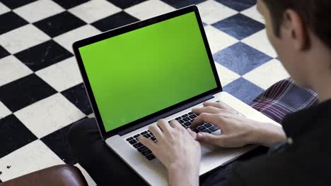 person using a laptop with a green screen