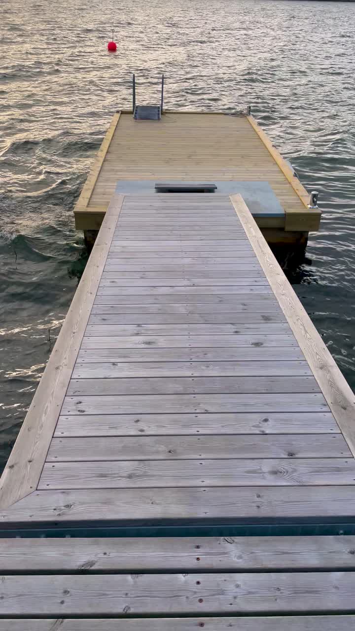 Empty wooden jetty extending over calm waters at sunset