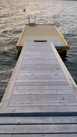 empty wooden jetty extending over calm waters at sunset