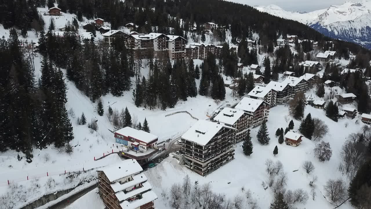 vista aérea de los edificios de apartamentos en la estación de esquí de los alpes suizos, inclinación hacia arriba revelada