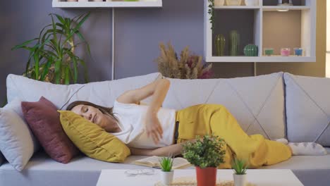 Mujer-Joven-Durmiendo-Con-Un-Libro-En-Un-Sofá.