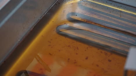 dirty deep fryer with oil and heating elements