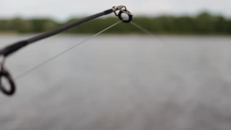 the tip of a fishing rod on the lake