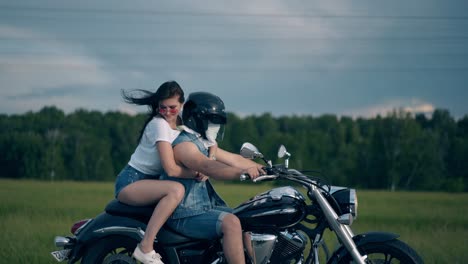 gorgeous lady in sunglasses hugs man driving motorbike