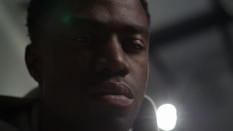 close up low key lighting shot looking up into face of unhappy and depressed young man