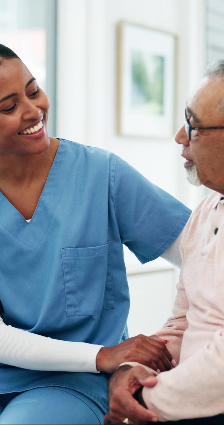Friendly Nurse Comforting Senior Patient in Hospital