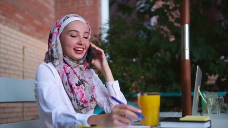 young woman talking on phone in cafe