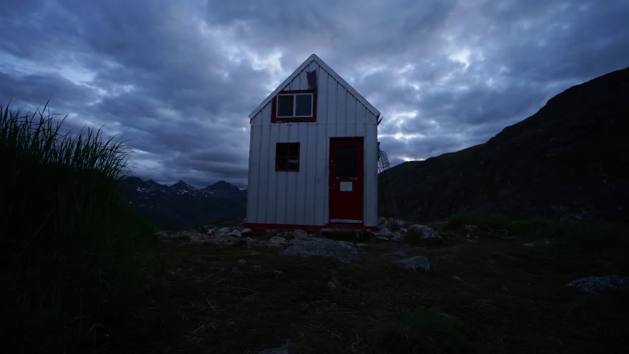 lapso de tiempo de una estructura al aire libre en el cepillo de alaska al atardecer con nubes rodando sobre la cabeza