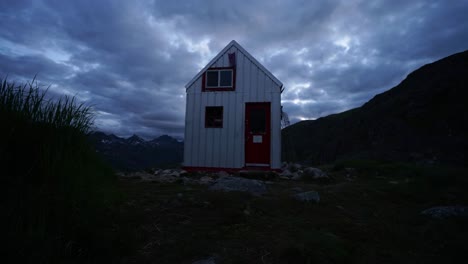 time lapse of an outdoor structure in the alaskan brush at dusk with clouds rolling over head