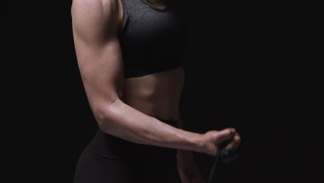 close up studio shot of mature woman wearing gym fitness clothing exercising with resistance band