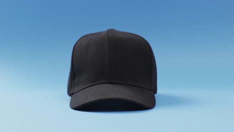 video of black baseball cap and copy space on blue background