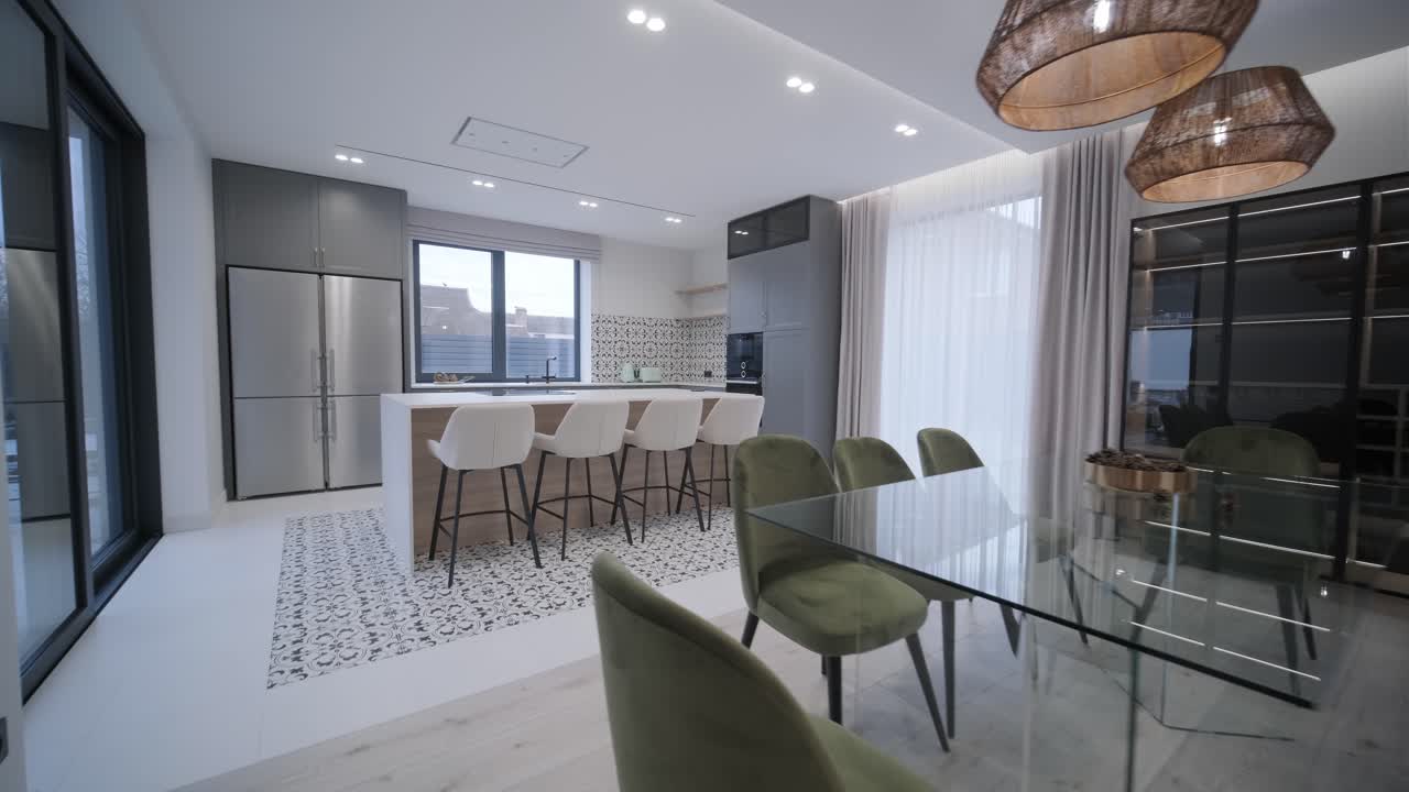 área de comedor moderna y elegante con elegantes sillas verdes, una mesa blanca, y luces colgantes de mimbre, acentuadas por tonos neutrales y luz natural