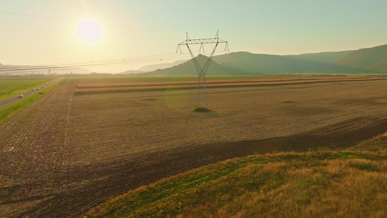 Aerial View of Electricity Pylon in Agricultural Field at Sunset