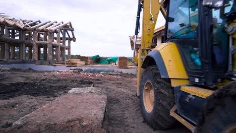 log cabin under construction with excavator