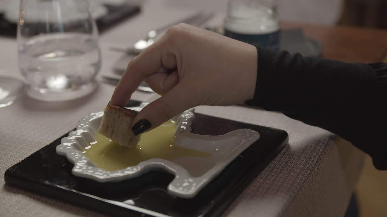 Una signora assaggia l'olio d'oliva in un ristorante