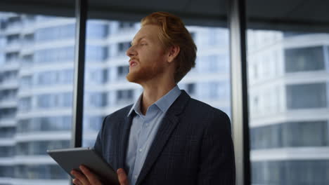 businessman reading bad news on digital tablet. entrepreneur breathing deeply