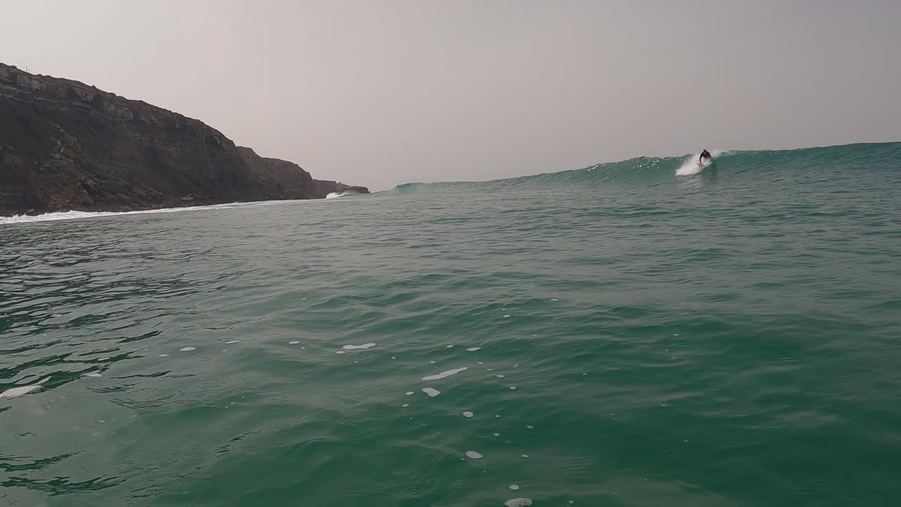 hombre surfista surfeando la ola del océano al amanecer, hermosa ola del océano, estilo de vida de surf, cámara lenta cinematográfica, filmada en cámara roja