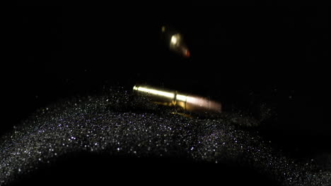 bullets of 300 aac blackout and 6mm arc slowly fall into heap over gunpowder