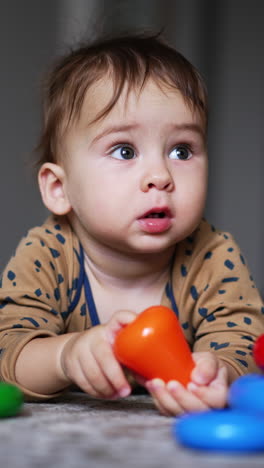 small cute boy playing with colorful toys. educational baby activity with toy. vertical video