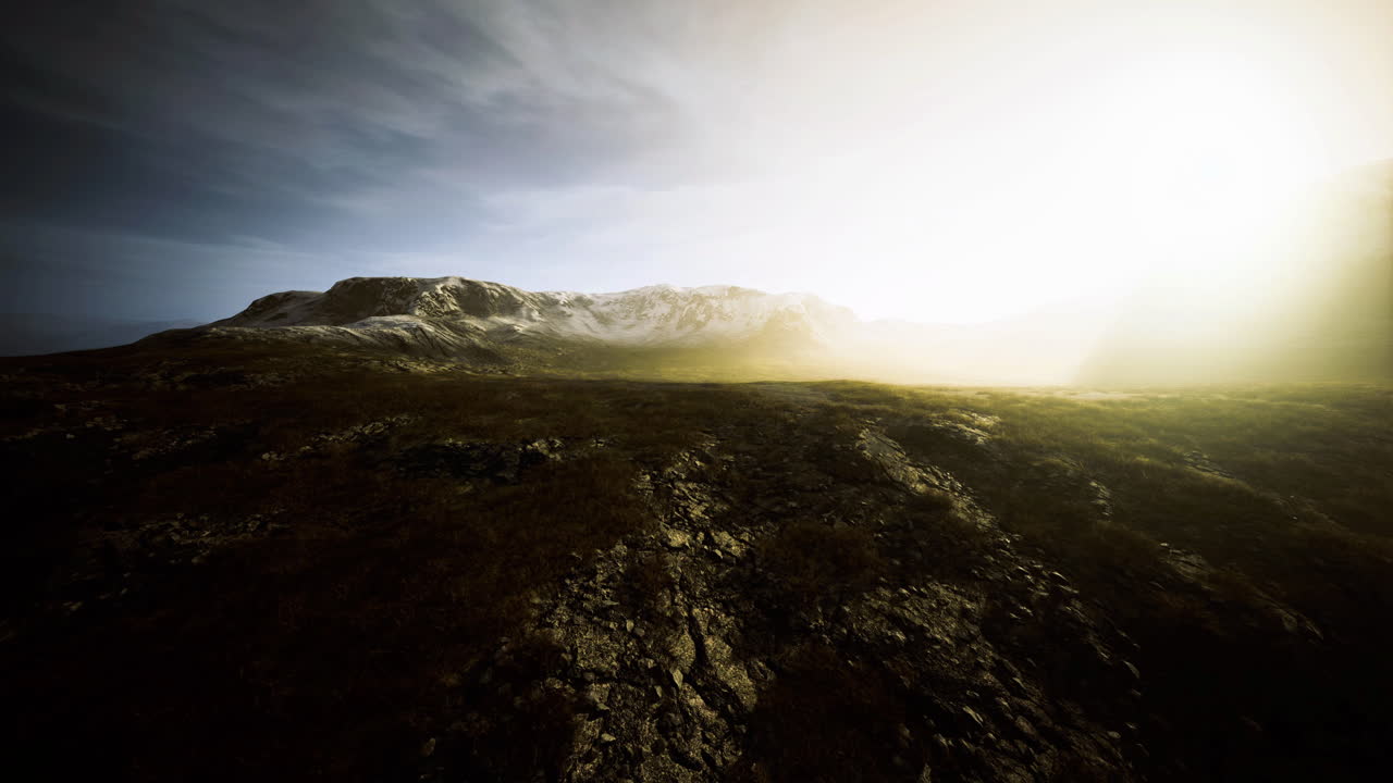 Scenic landscape view with sunlight shining over mountains during sunset